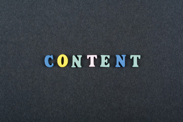 CONTENT word on black board background composed from colorful abc alphabet block wooden letters, copy space for ad text. Learning english concept.