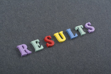 RESULTS word on black board background composed from colorful abc alphabet block wooden letters, copy space for ad text. Learning english concept.