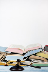 Law concept open book with wooden judges gavel on table in a courtroom or law enforcement office, white background. Copy space for text.