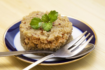 Quinoa dish  and fork on wooden table