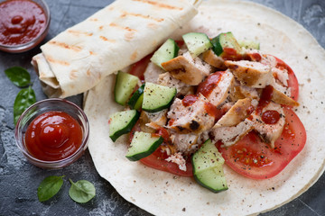 Close-up of shawarma or shaurma with roasted chicken meat and fresh vegetables