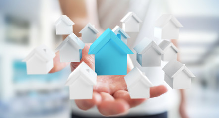 Businessman using 3D rendered small white and blue houses