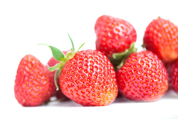 Beautiful strawberry fruits on white. Red fresh berries with green leaves. Closeup shallow depth of field photography