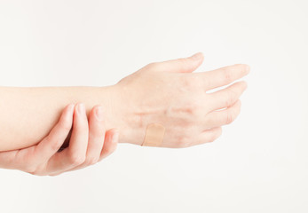 Sticking plaster on hand on white background