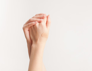 Sticking plaster on hand on white background