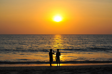 Fototapeta premium Beautiful Sunset at andaman sea with silhouette people together