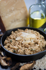 Risotto with ceps and parmesan cheese in a frying pan, close-up, vertical shot