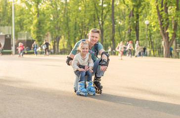 Fototapeta premium little girl and her father posing and roller skating