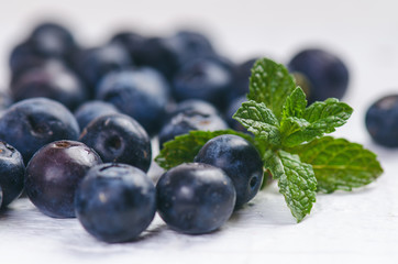 Fresh blueberries with mint on a wooden white table. Natural antioxidant. Concept of healthy food. Organic superfood