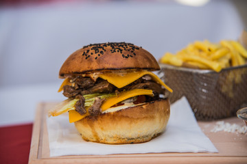 Sandwich hamburger with juicy burgers cheese and mix of vegetables.