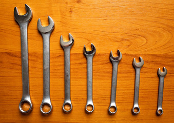 Set of metal wrenches on a wooden background.