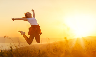 Happy woman  jump,  rejoices,  on sunset in nature - Powered by Adobe