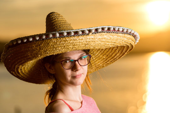Young Woman With Sombrero On The Beach At Sunset