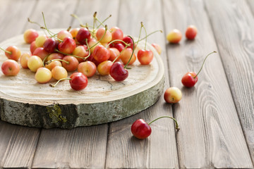 Ripe red yellow cherries on cross tree section