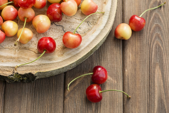 Ripe red yellow cherries on cross tree section