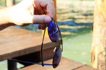 Sunglasses in hand © Yana