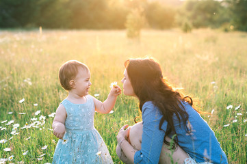 Happy young mother with baby girl walking outside.