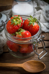 Strawberry in jar on wooden background.