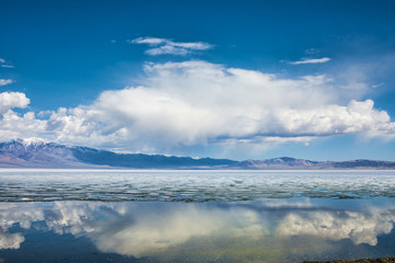 panoramic view of fluffy white clouds reflecting in watery surface of lake
