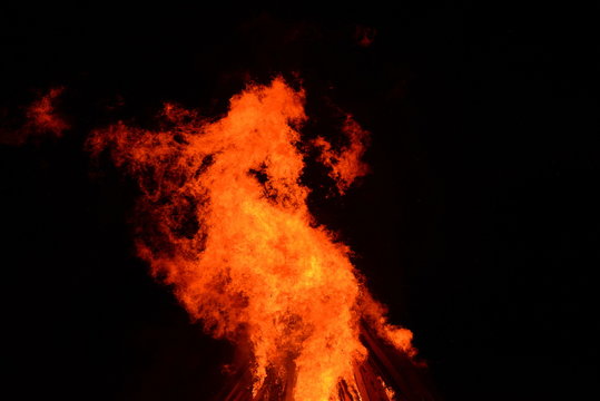 Feuerdrache, wild loderndes Feuer vorm Nachthimmel
