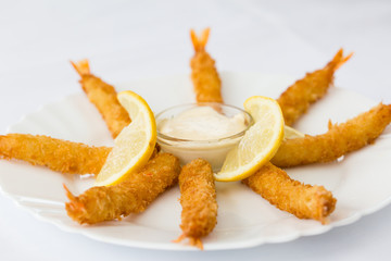 Fried shrimp sticks in white plate at restaurant