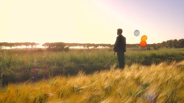 Young businessman in the middle of the nature with baloons