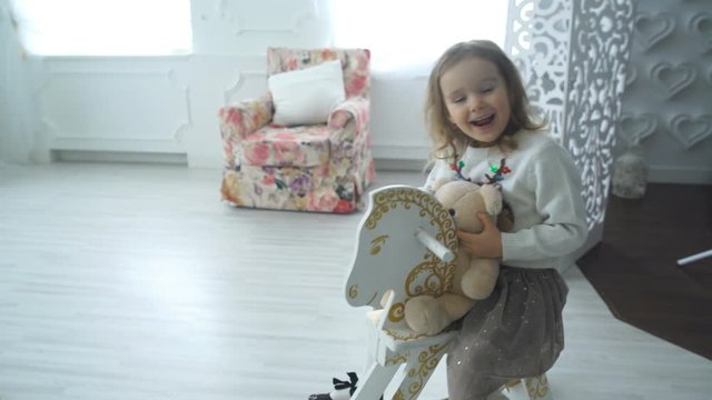 girl on a toy horse at home