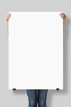 Woman holding a blank A0 poster mockup isolated on a gray background.