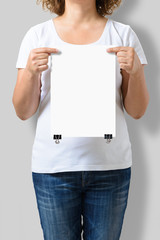 Woman holding a blank A4 poster mockup isolated on a gray background.