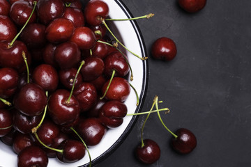 Cherry in a plate close-up on a black background.