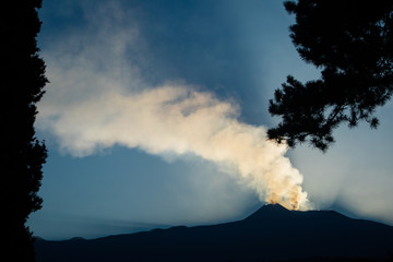 View of the mount Etna smoking at sunset