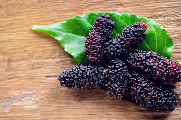 Mulberry and  leaves on a wooden background,Red and black berry fruit.