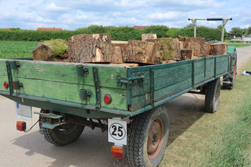 Traktor und Anhänger mit Holz beladen