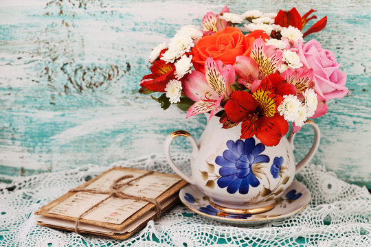 Bouquet roses and old letters on wooden desk in a vintage style.