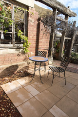 A small intimate courtyard with a single table and two chairs. Copyspace.