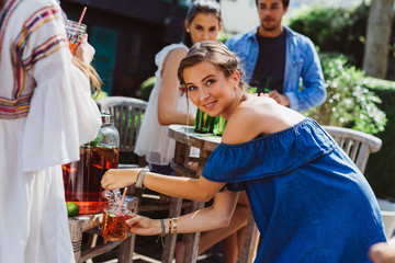 Frau holt sich Getränk von Bar
