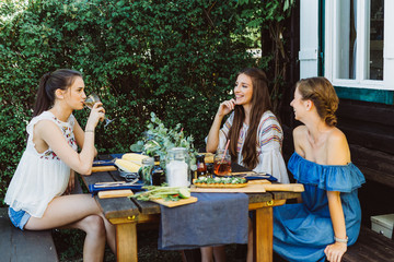Drei Frauen draußen am Tisch mit Essen