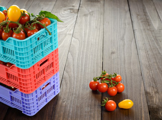 Fresh ripe tomatoes are in the boxes on broun wooden table