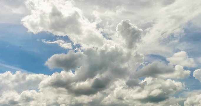Time lapse clip of white fluffy rolling storm clouds over blue sky