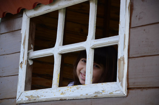 Ni&ntilde;a hispana observando a trav&eacute;s de la ventana