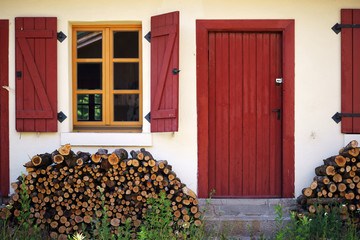 Holz vor der Hütte  / Eine Hütte mit Brennholz vor der Eingangstür und mit Fensterläden an den...