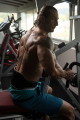 Fototapeta na wymiar Bodybuilder Exercising Back In Gym