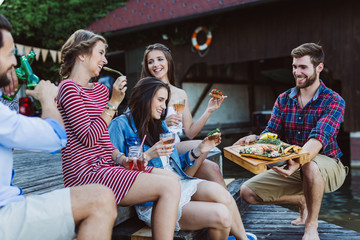 Girls getting barbecue food plate served from guy
