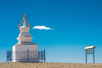 ancient traditional white stupa surrounded by metal fence at sunny day
