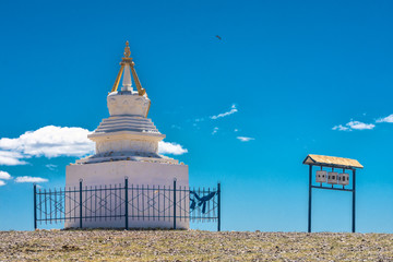 ancient traditional white stupa surrounded by metal fence at sunny day
