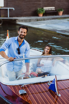 Handsome captain with girl in boat on lake
