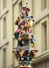 The Kindlifresserbrunnen fountain sculpture in Bern, Switzerland depicts a sitting ogre devouring a...