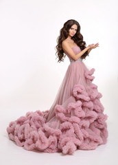 Beautiful girl Lady in luxury lush pink dress. Fashion brunette woman in gorgeous long gown posing...