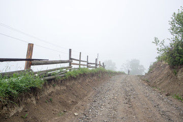 Fototapeta na wymiar man's silhouette on mountains road in the fog