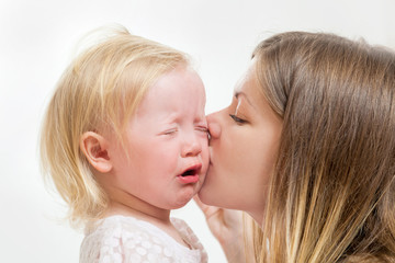 mother kisses the crying girl
